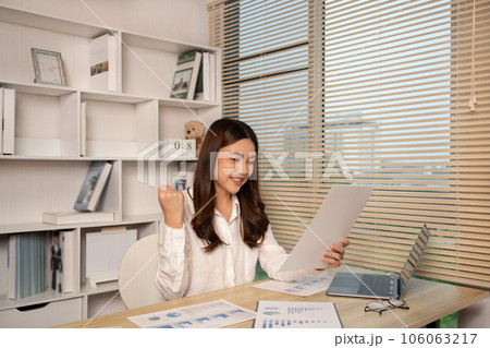 Joyful, Surprised or shocked Asian woman raised her arms all the way because she did a good job the boss gave her a big bonus making her very happy, Raise your hand, Smiling and screaming for success. 106063217