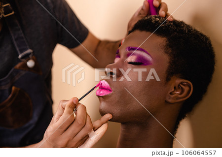 Makeup artist doing makeup on an African transgender person. 106064557