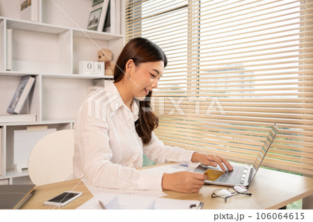 Woman's finger presses a keyboard and holds a credit card to register for payment or online transactions, Financial transactions and Internet security, Shopping online and banking online concept. 106064615
