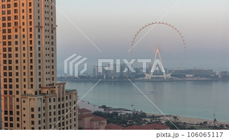 Bluewaters island with modern architecture and ferris wheel aerial night to day timelapse. Bluewaters island with modern architecture and ferris wheel aerial night to day timelapse. 106065117