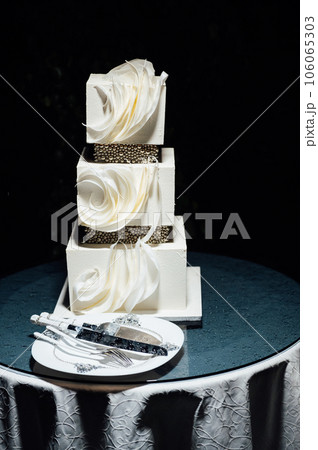 Premium square form wedding cake three floors at the evening ceremony Premium square form wedding cake three floors at the evening ceremony 106065303