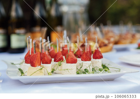 Light appetizer cheese and strawberries for guests at a wedding buffet. Waiting for a wedding ceremony 106065333