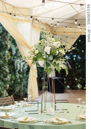 A beautiful vase of flowers on a table in a luxury restaurant. Wedding decorations A beautiful vase of flowers on a table in a luxury restaurant. Wedding decorations 106065339