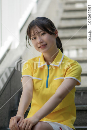 階段に座る黄色いユニフォームを着たコンパニオン風の女子高生 階段に座る黄色いユニフォームを着たコンパニオン風の女子高生 106066592