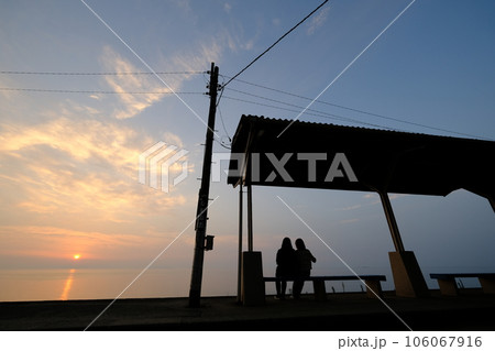 瀬戸内海に沈む夕日が下灘駅の二人を照らす 106067916