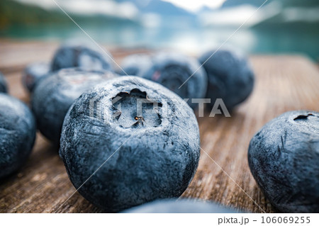 Blueberry antioxidants on a wooden table on a background of Norwegian nature. 106069255