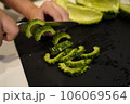 ゴーヤを切る女性の手元 106069564
