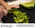 ゴーヤを切る女性の手元 106069565