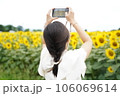 ひまわり畑を撮影する女性 106069614