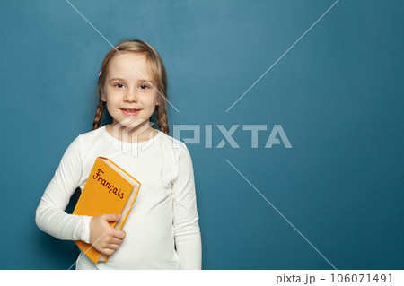 Child student girl with French language book on the background of blue chalkboard 106071491