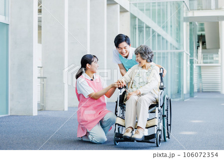 車いすの高齢者と介護する若いヘルパー 車いすの高齢者と介護する若いヘルパー 106072354