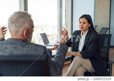 Two business colleagues talking in meeting room during work on project. Teamwork concept Two business colleagues talking in meeting room during work on project. Teamwork concept 106072524