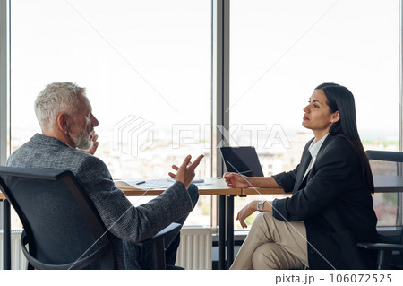 Two business colleagues talking in meeting room during work on project. Teamwork concept 106072525