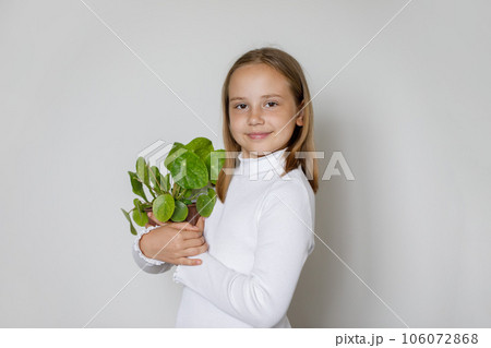 Child with green plant on white background 106072868