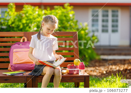 girl is having lunch sitting next to the school girl is having lunch sitting next to the school 106073277