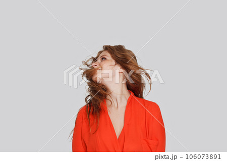 Happy model woman with long ginger healthy blowing hair, studio portrait Happy model woman with long ginger healthy blowing hair, studio portrait 106073891