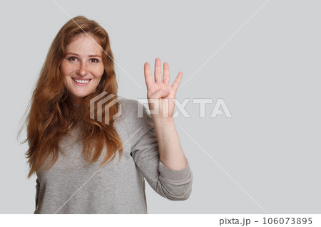 Cute smiling woman showing four finger on white background 106073895
