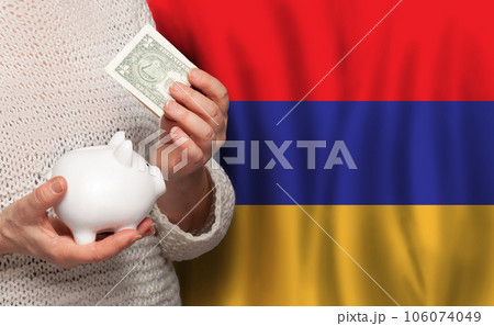 Armenian woman with money bank on the background of Armenia flag. Dotations, pension fund, poverty Armenian woman with money bank on the background of Armenia flag. Dotations, pension fund, poverty 106074049