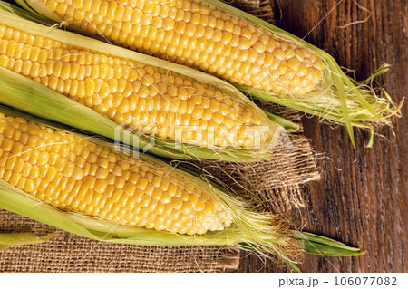 Corn on a brown wooden background 106077082