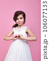 Adorable little girl showing heart gesture with hands on pink studio background 106077133