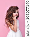cute little girl in a beautiful dress with hairstyle and make-up on a pink background 106077140