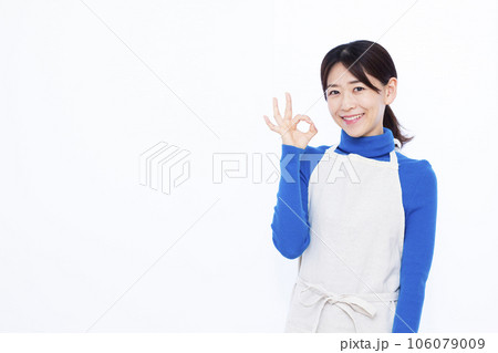 白い背景の前でOKサインをしている30代の主婦 白い背景の前でOKサインをしている30代の主婦 106079009