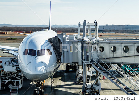 駐機場で待機する飛行機とボーディングブリッジの風景 駐機場で待機する飛行機とボーディングブリッジの風景 106084511