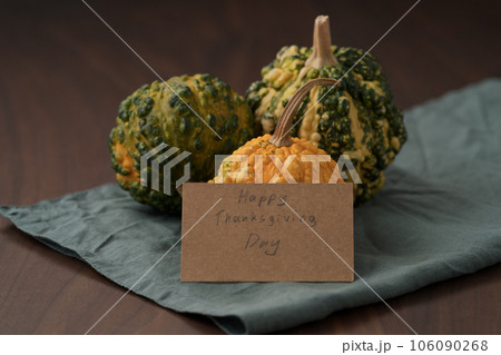 decorative pumpkins on walnut wood table with thanksgiving day paper card decorative pumpkins on walnut wood table with thanksgiving day paper card 106090268