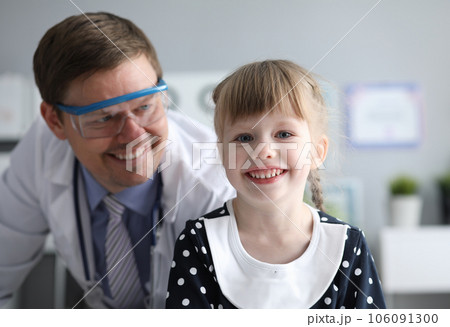 Smiling male doctor looking healthy happy child Smiling male doctor looking healthy happy child 106091300