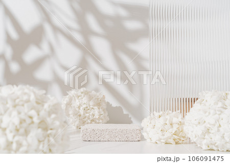 Cosmetics skin care product presentation scene made with empty pumice stone podium and white flowers on bathroom shelf. Cosmetics skin care product presentation scene made with empty pumice stone podium and white flowers on bathroom shelf. 106091475