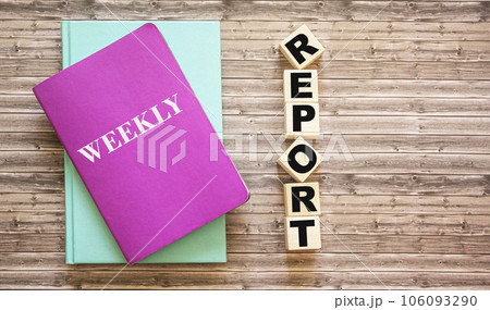 On a wooden table, cubes with the text Report and colored diaries. On a wooden table, cubes with the text Report and colored diaries. 106093290