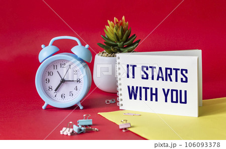 It starts with you, the phrase is written on a notebook and a red and yellow background 106093378