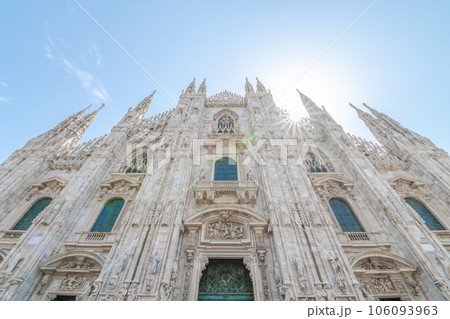 Milan Cathedral, Italian: Duomo di Milano, or Metropolitan Cathedral-Basilica of the Nativity of Saint Mary. View of main door and white marble facade on sunny summer day. Milan, Lombardy, Italy 106093963