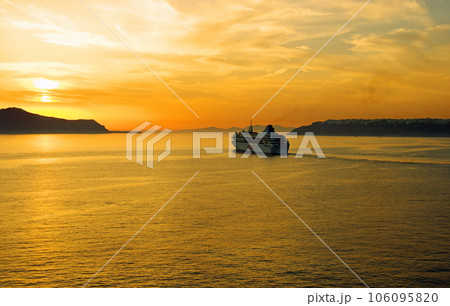 夕陽に向かってサントリーニ島を出港するクルーズ船 106095820