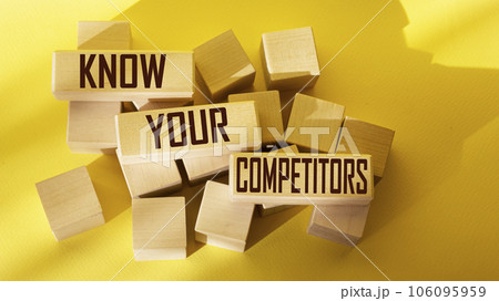 The text KNOW YOUR COMPETITORS is written on wooden blocks and on a yellow background. 106095959