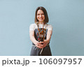 The artist holds brushes in her hands. Blurred background. 106097957