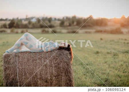 sexy young nude girl topless lying on haystack in field in summer. Added the effect of a small film grain 106098124