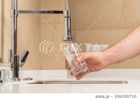 filling a glass with clean, clear drinking water 106100710