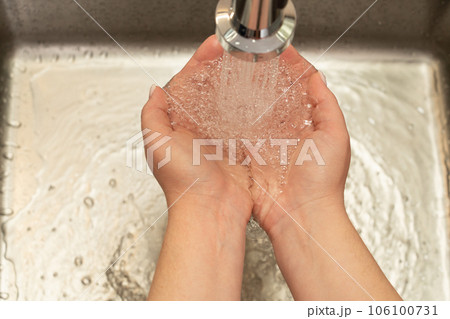 water flowing from the faucet into the hands water flowing from the faucet into the hands 106100731
