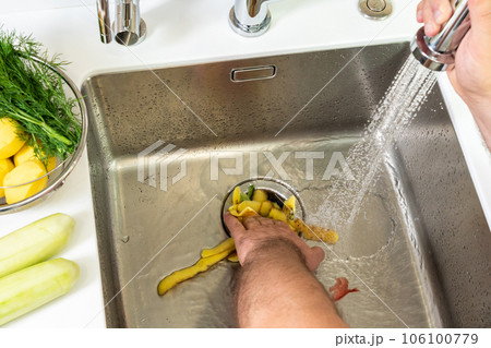 A man destroys food waste with a disposal 106100779