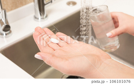 medical tablet in hand before taking it with water medical tablet in hand before taking it with water 106101076