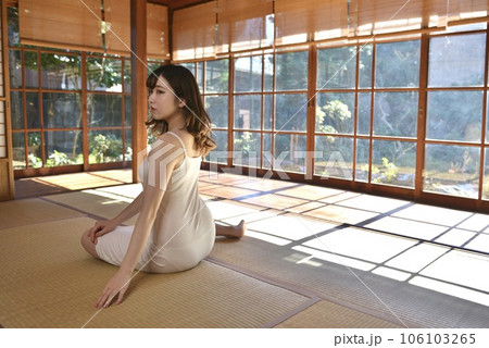 畳の上に座り微笑むキャミソール姿の若い女性 106103265