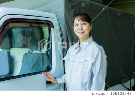 トラックの前に立つ作業着の女性 トラックの前に立つ作業着の女性 106103348