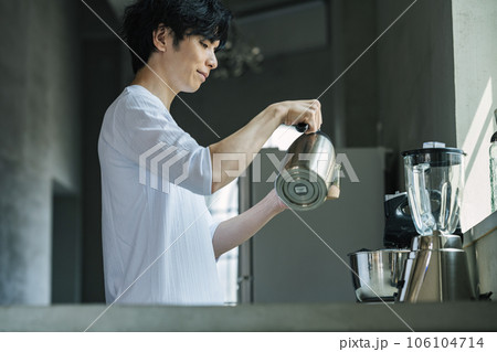 おしゃれなキッチンでコーヒーを淹れる男性 106104714