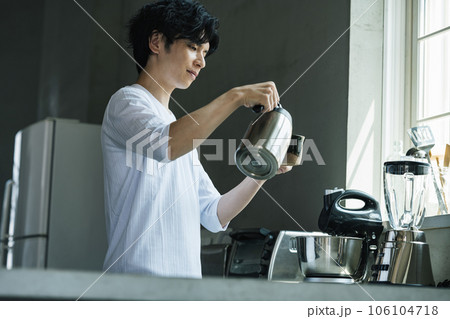 おしゃれなキッチンでコーヒーを淹れる男性 106104718
