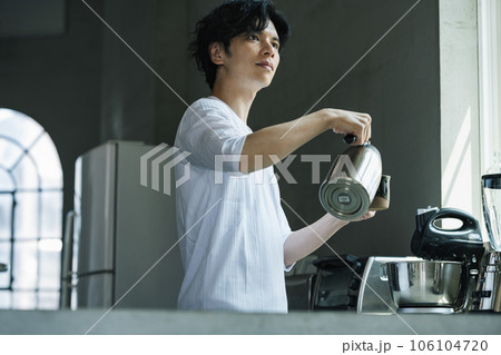 おしゃれなキッチンでコーヒーを淹れる男性 106104720