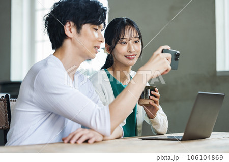 テーブルで一緒にスマホを見る男女カップル 106104869