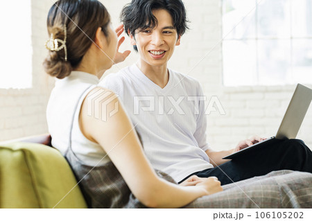 家のリビングで話す男女カップル 106105202