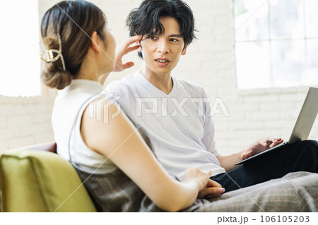 家のリビングで話す男女カップル 106105203