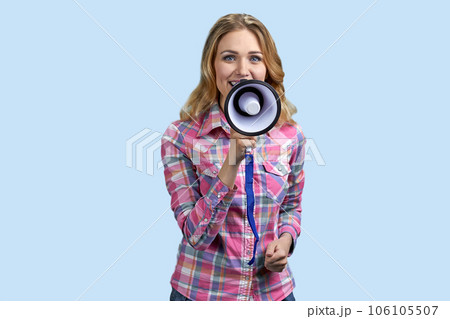 Young blonde blue-eyed woman holding a megaphone. Isolated on pastel blue background. 106105507